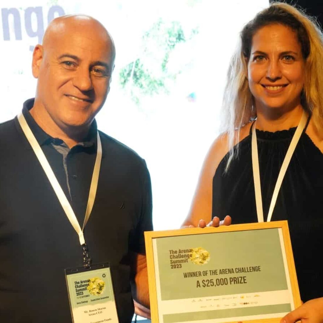 Ronen Sharon, head of commercial real estate at Reality Group, giving the Arena Challenge startup competition award certificate to Moran Kirshner Goldberg, CEO of Zohar Cleantech. Photo courtesy of Reality Group