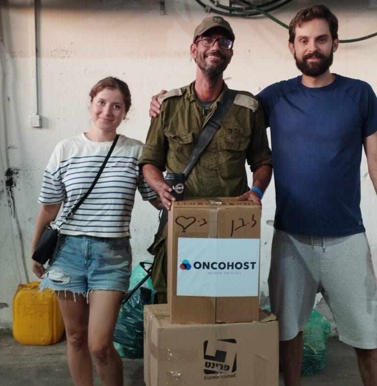 OncoHost Director of R&D Ben Yellin, center, receiving a care package from fellow employees at his base, organized by Oshrit Regev Rokach, head of HR. Photo courtesy of OncoHost
