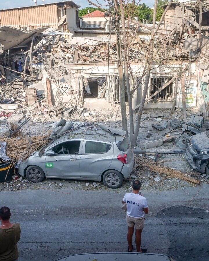 Israelis examine the destruction after a building in Tel Aviv’s Florentin neighborhood was hit by a missile from Gaza on October 8. Photo by Avshalom Sassoni/Flash90