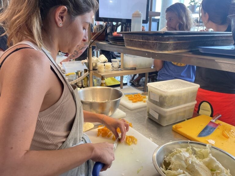 A volunteer dicing vegetables at Asif Culinary Instituteâ€™s war kitchen. Photo by Natalie Selvin