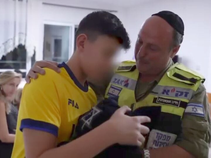 Ariel Zohar receiving his dead father’s tefillin from ZAKA volunteer Chaim Otmazgin. Photo: screenshot
