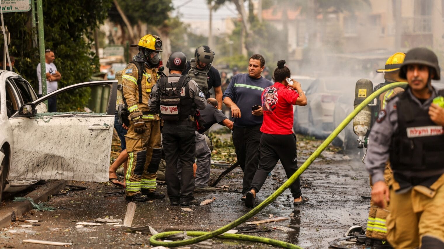 Firefighters extinguishing cars hit by missiles in the southern Israeli city of Ashkelon, October 9, 2023. Photo by Chaim Goldberg/Flash90
