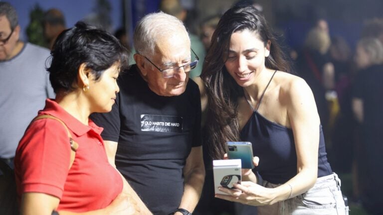Shani Bibi, right, presenting a smartwatch to a deaf resident of Tel Aviv. Photo by Shlomi Yosef