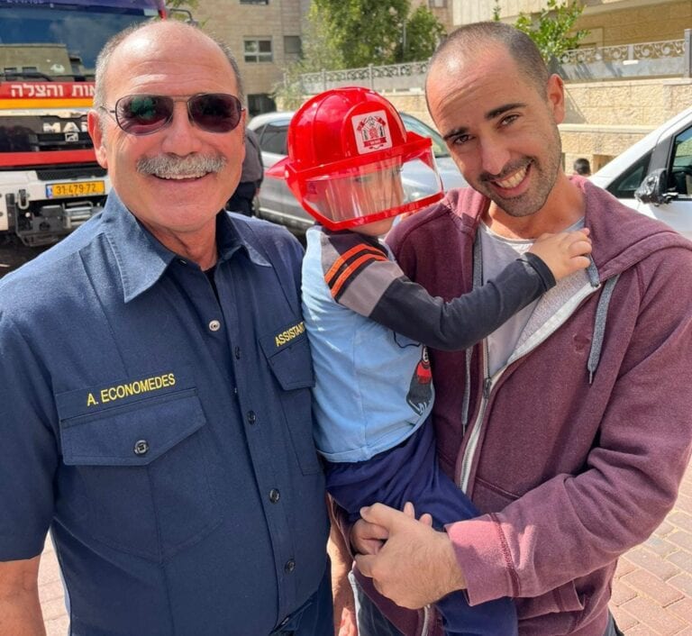 American firefighters, in Israel during the war through the Emergency Volunteers Project, brought some joy to a child at his motherâ€™s funeral. Photo courtesy of EVP