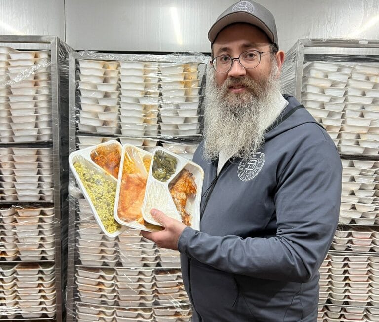 Rabbi Menachem Traxler, director of Pantry Packers, with meals ready to go to displaced families in Jerusalem. Photo courtesy of Colel Chabad