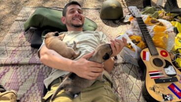 Soldier Saâ€™ar Berkowitz bottle-feeding abandoned puppies. Photo courtesy of Ilana Curiel