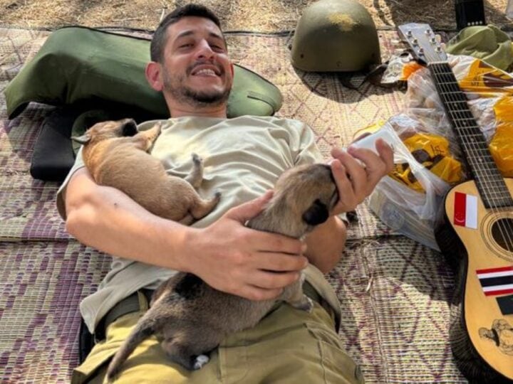 Soldier Saâ€™ar Berkowitz bottle-feeding abandoned puppies. Photo courtesy of Ilana Curiel