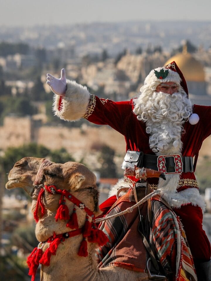 Issa Kassissieh, dressed as Santa Claus rides on a camel at Mount of Olives, overlooking the Old City of Jerusalem, ahead of the upcoming holiday of Christmas, December 4, 2023. Photo by Jamal Awad/Flash90