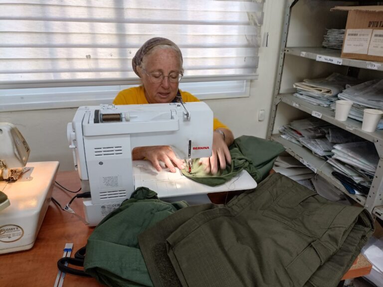 Judy Slyper tailoring XL army uniforms for soldiers. Photo by Lisa Zenilman