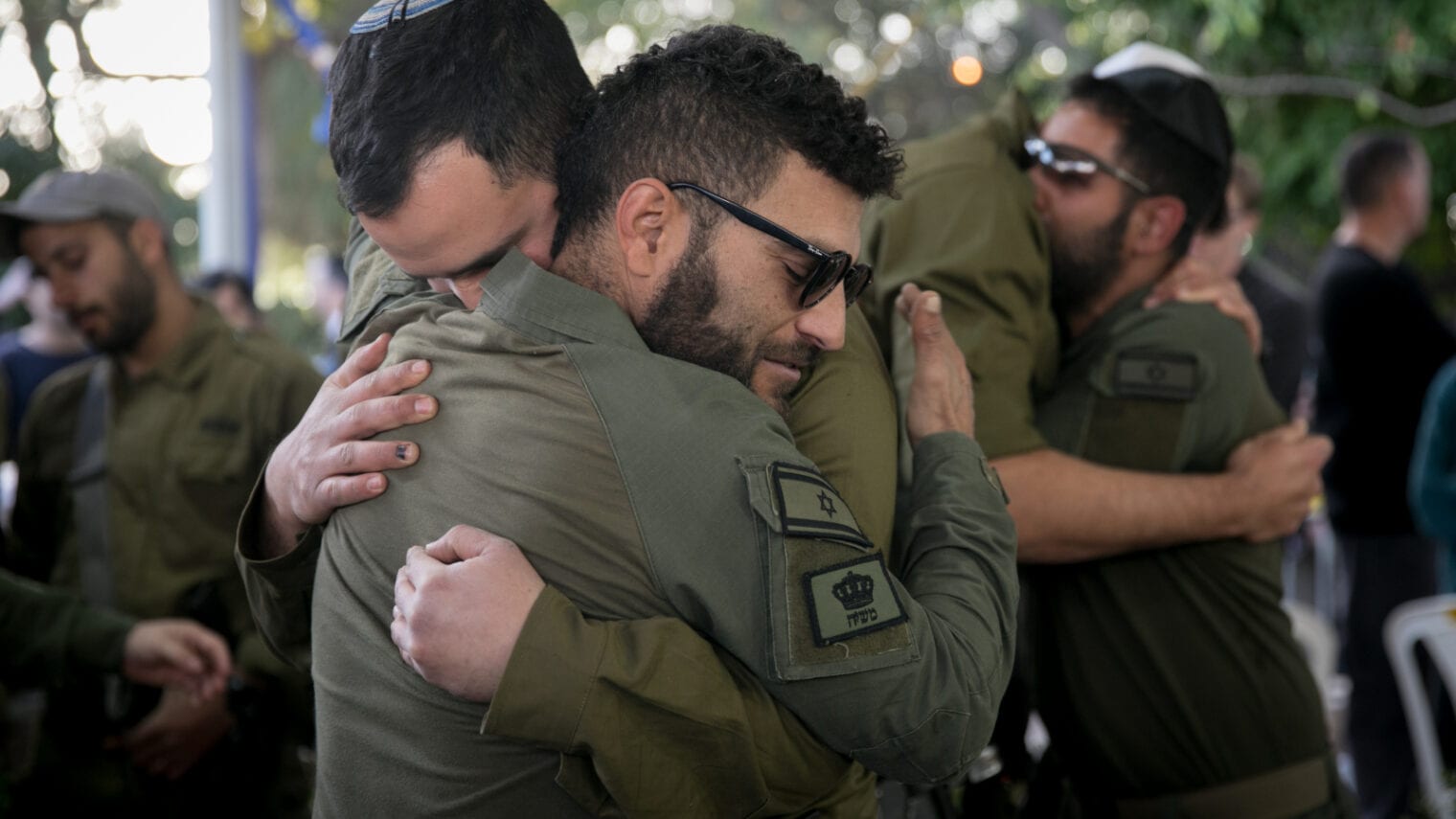 Soldiers comfort one another at the funeral of Master Sergeant (res.) Akiva Yasinsky at Kiryat Shaul Military Cemetery, on January 10, 2024. Yasinsky was killed in Gaza. Photo by Miriam Alster/Flash90