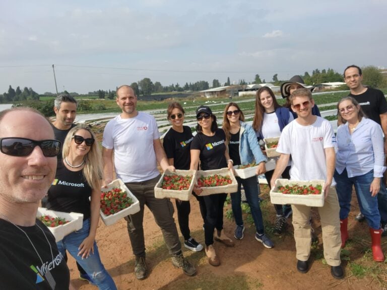 One Heart CEO Tomer Dror and volunteers, including Microsoft employees, helping farmers with strawberry picking. Photo courtesy of One Heart