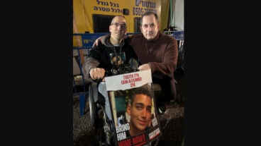 Genesis Prize Co-founder Stan Polovets (right) with Doron Zexer, who holds a picture of Edan Alexander, one of several lone soldiers he hosts in his home in Israel. Photo courtesy of the Genesis Prize Foundation