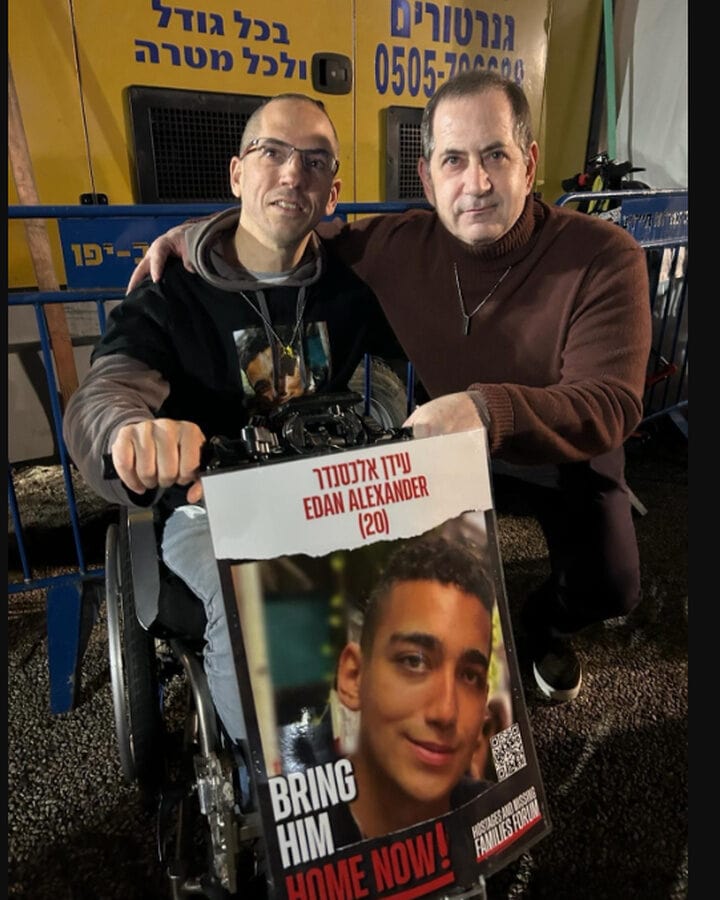 Genesis Prize Co-founder Stan Polovets (right) with Doron Zexer, who holds a picture of Edan Alexander, one of several lone soldiers he hosts in his home in Israel. Photo courtesy of the Genesis Prize Foundation