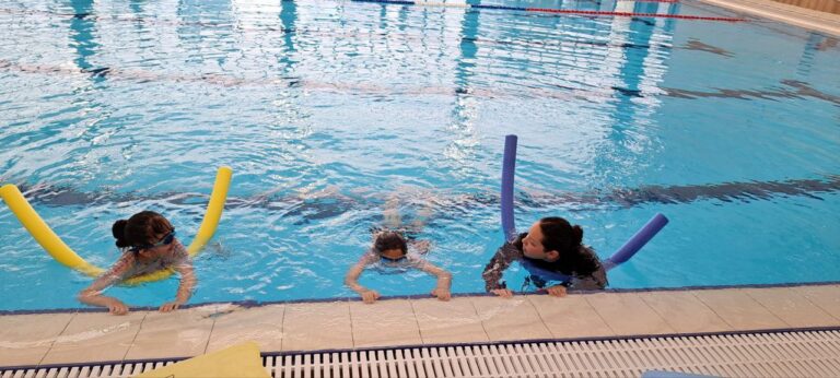 Ella Azaria instructing two girls in the pool. Photo courtesy of Swimming Toward Resilience