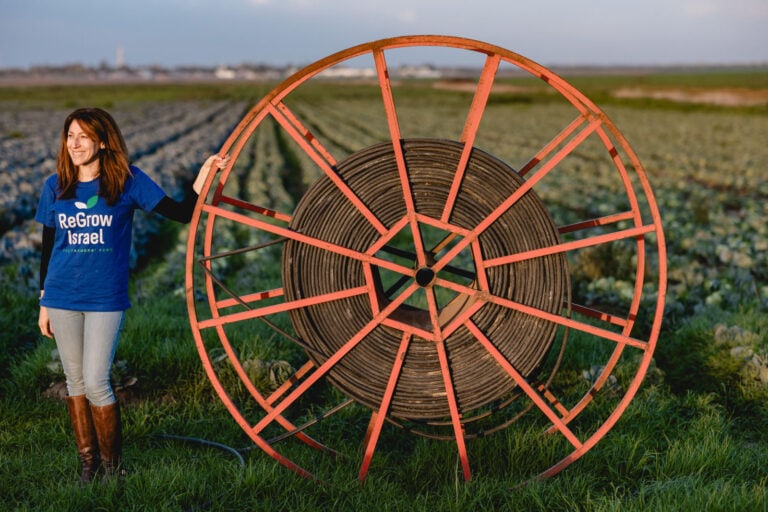 Danielle Abraham beside an irrigation wheel on a Western Negev farm. Photo by Kari Warberg Block/Ran Bergman Photography