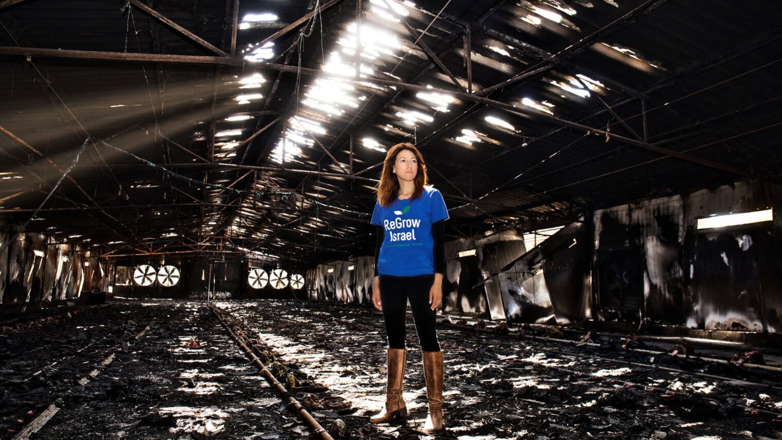 Danielle Abraham stands in an agricultural shed destroyed by Hamas terrorists on October 7, in Nir Oz. Photo by Noam Chen