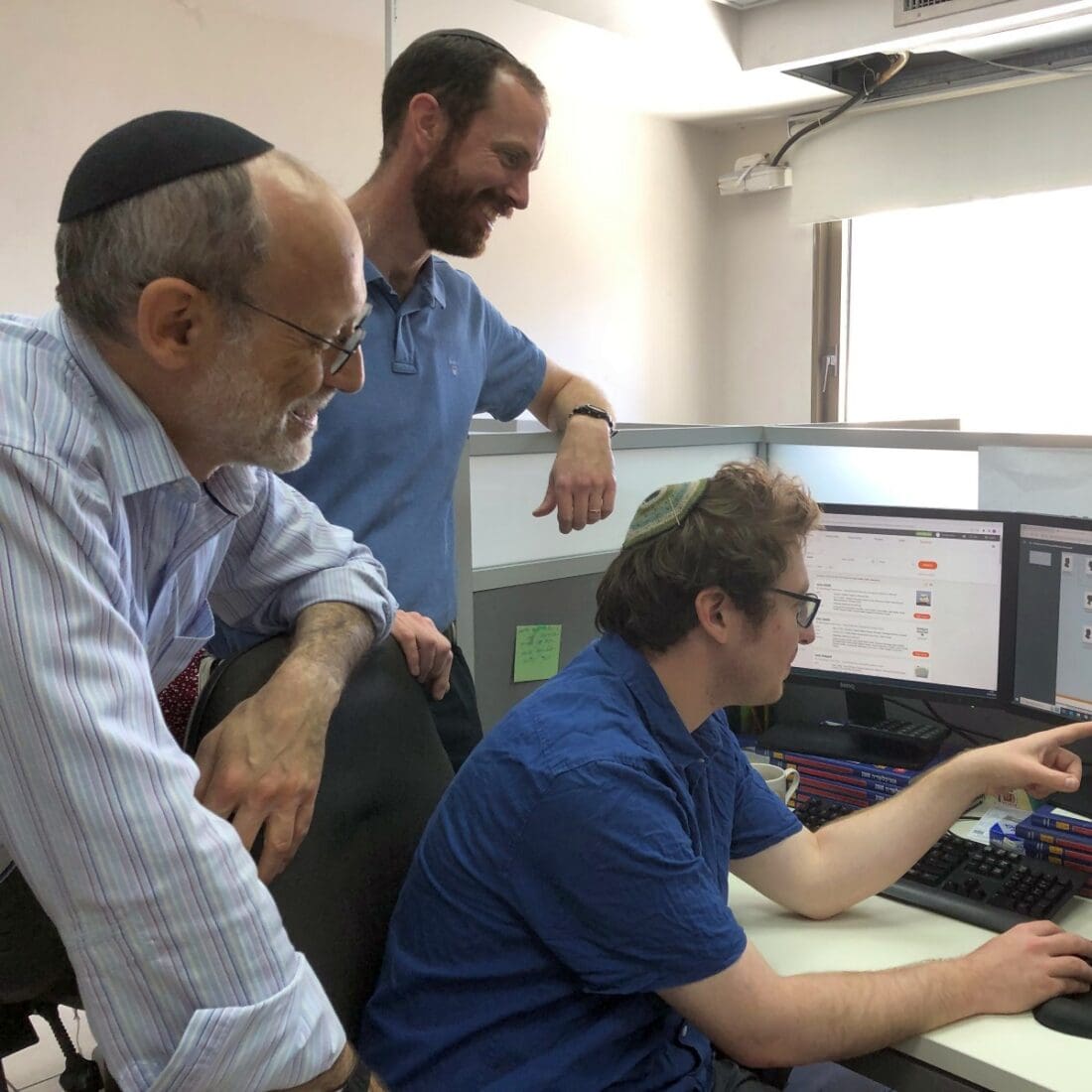 From left, Jonathan Kirsch, department head in the unit for the location and restitution of unclaimed property; JCT team leader Avraham Schumacher; and researcher Quincy Barrett discussing a JCT file.