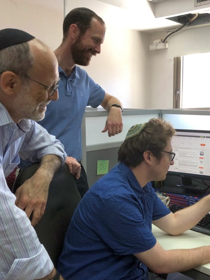 From left, Jonathan Kirsch, department head in the unit for the location and restitution of unclaimed property; JCT team leader Avraham Schumacher; and researcher Quincy Barrett discussing a JCT file.