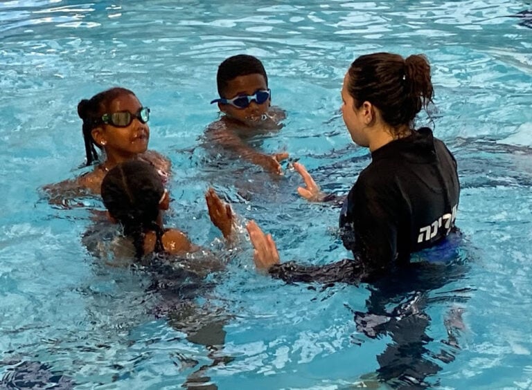 Ella Azaria instructing children of Ethiopian descent. Photo courtesy of Swimming Toward Resilience