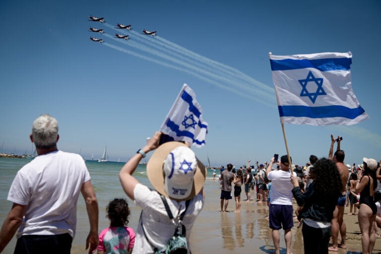 People at the beach in Tel Aviv watch the military airshow as part of Israel's 75th Independence Day celebrations, April 26, 2023. Photo by Avshalom Sassoni/Flash90