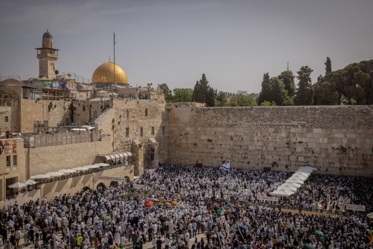 Jewish worshippers at the Western Wall (Kotel), a retaining wall of the destroyed Second Temple compound. At left on the Temple Mount above is the Muslim Dome of the Rock. Photo by Chaim Goldberg/Flash90