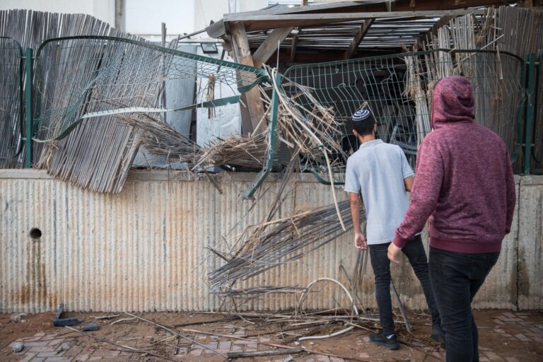 Israelis inspect damage from a rocket fired from Gaza that hit their back yard in Sderot, July 14, 2018. Photo by Hadas Parush/Flash90
