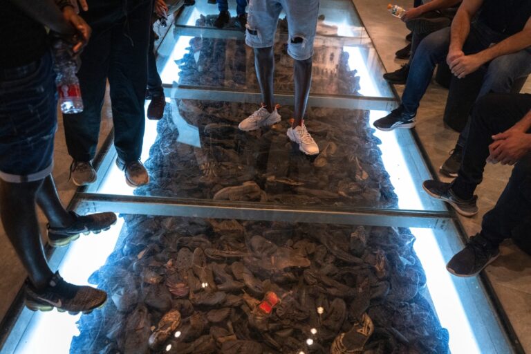 Visitors at Yad Vashem looking at the collection of Holocaust victims’ shoes. Photo by Olivier Fitoussi/Flash90