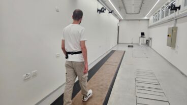 A person walking in a gait lab with a wearable sensor positioned on his lower back. Photo courtesy of Tel Aviv University
