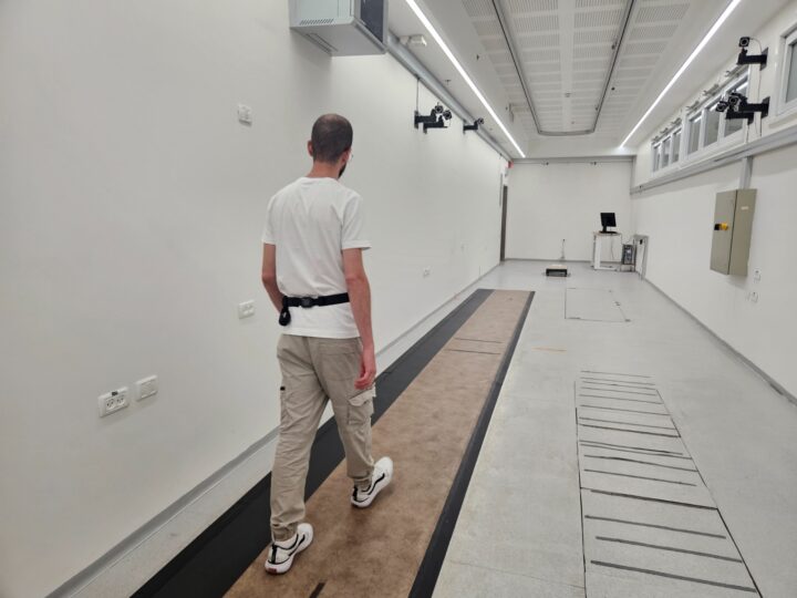 A person walking in a gait lab with a wearable sensor positioned on his lower back. Photo courtesy of Tel Aviv University